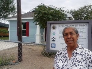 Doña Maria Gomez poses in front of her new home constructed with disaster recovery funds